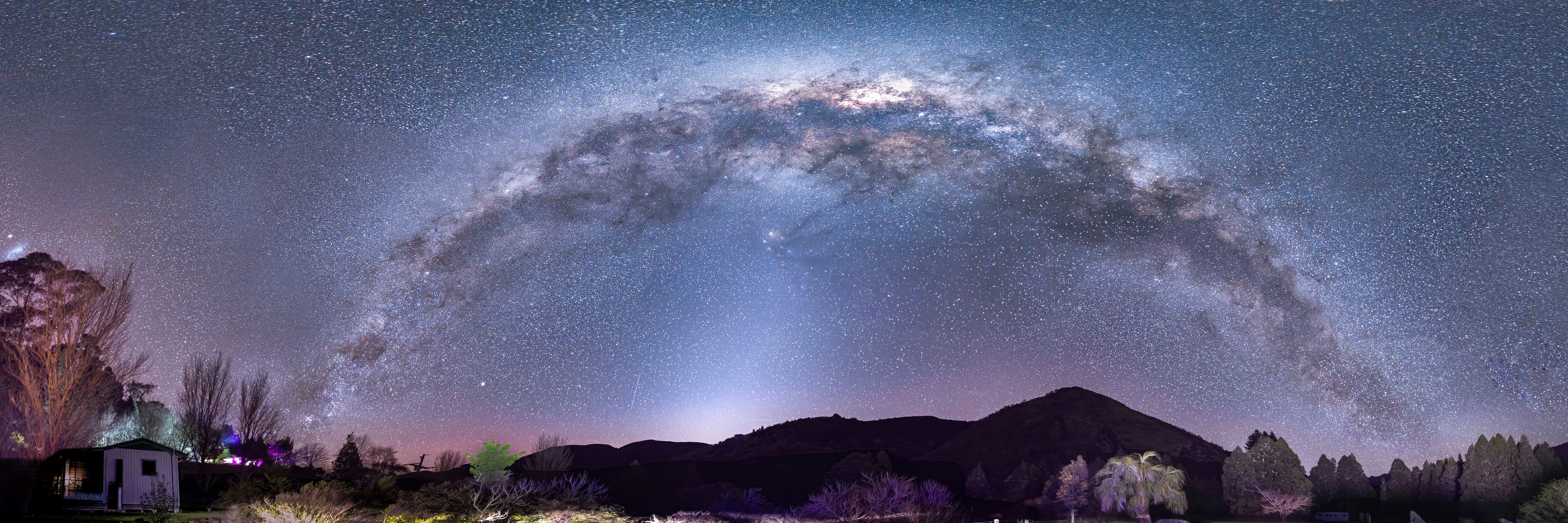 Panorama of a starry night sky over a our accommodation with mountains in the background